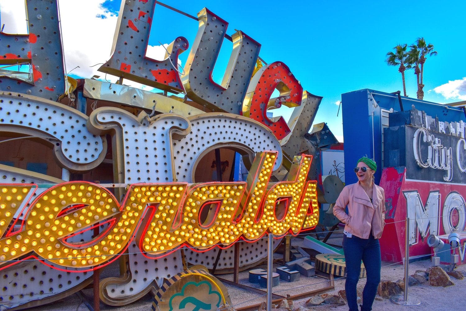woman standing in front of an old neon sign at the Neon Boneyard in las vegas