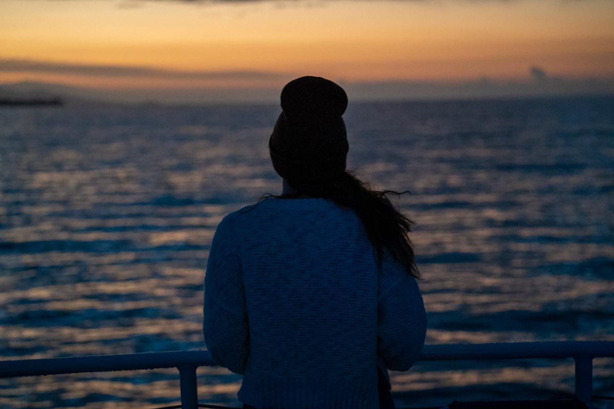Woman on a Maui whale watching tour at sunrise